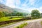 Scenic view of a valley with a country road in the foreground at the sunny day in Lake District National Park, Cumbria, England, U