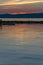 Scenic view of vivid sunset reflection on calm water, silhouette of rowing boat.