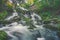 Scenic  view of a waterfall splashes over the mossy rocks