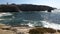 Scenic view of the wavy sea and coastline rocks under the clear sky in Peniche, Portugal
