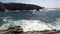 Scenic view of the wavy sea and coastline rocks under the clear sky in Peniche, Portugal