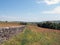 Scenic view of west yorkshire countryside with a long dry stone wall in summer meadows with hills farms and fields in the distance