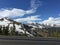 Scenic view of a winding country road surrounded by vibrant-hued trees and snow-capped mountains