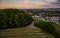 Scenic view of a winding road leading towards a quaint rural town in the countryside