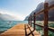 Scenic view on wooden planks pier with railings built on northern shore of beautiful Garda lake in Lombardy, Italy surrounded by