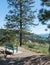 Scenic viewpoint on Kettle Valley Rail Trail with park bench overlooking Okanagan Valley and Okanagan Lake