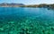 Scenic views of the seabed with green stones, a city on the shore and a small boat in bay of island Crete, Greece.