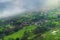 Scenic Vista View of Peaceful Countryside Village with Lush Green Rice Terrace Field on Mountain