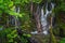 Scenic waterfall deep in the forest with fallen trees, streams o