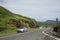 Scenic winding drive in Oahu, with a car parked on the curb