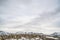 Scenic winter landscape with cloudy sky over striking mountain and hill homes