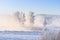 Scenic winter landscape in the foggy morning. Beautiful snowy nature at sunrise. Cold misty river in frost on clear morning.