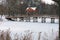 Scenic winter landscape view of old wooden bridge over the frozen lake in the village of Pushcha-Voditsa.