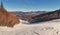 Scenic winter scene featuring a ski slope with fresh snow blanketing and majestic mountains