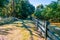 Scenic wooden farm fence and rows of apple trees.