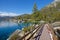 Scenic wooden path leading along the edge of spectacular lake in the mountains.