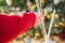 Scent of Christmas.incense sticks in a womans hand on a Christmas tree background. Christmas atmosphere.Hands putting