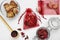 Scented sachets with dried rose and hibiscus flowers on white table, flat lay