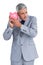 Sceptical businessman holding piggy bank