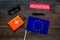 Schengen visa. Immigration to Europe concept. Text immigration near passport cover and european flag on dark wooden