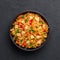 Schezwan Chicken Fried Rice in black bowl at dark slate background. indo-chinese cuisine dish