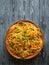 Schezwan Noodles with vegetables in a plate on a wooden table. Top view. Hakka Noodles is a popular Indo-Chinese recipes.