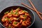 Schezwan Prawns in black bowl at dark slate background. Schezwan Prawns is indo-chinese cuisine curry dish