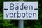 Schild an einem See mit den deutschen Worten Baden verboten