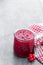 Schisandra jam in glass jar on gray background