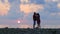 Schislivaya family: father, mother, baby son on the rocky sea beach during sunset. Parents play and kiss baby in the