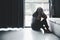 Schizophrenia with lonely and sad in mental health depression concept. Depressed woman sitting against floor at home with dark