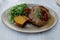 Schnitzel, cornbread, gravy and arugula salad on plate.