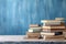 Scholarly serenity, Wooden table adorned with books, pastel blue backdrop