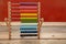 School abacus with colorful beads on wooden desk, close up view