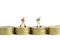 School admission budget.  Children or kids, walking above golden coin money stack. Miniature tiny people toys photography.