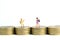 School admission budget.  Children or kids, walking above golden coin money stack. Miniature tiny people toys photography.