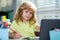 A school age boy does homework at home. Portrait of little schoolboy sitting at table, doing homework. Smart child doing