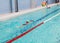 School age girl swims in pool with board. Young kids swimming training in Russian sports school