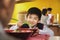 School boy eats noodles in school cafeteria