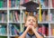 School boy in education library with graduation hat