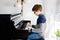 School boy with glasses playing piano in living room. Child having fun with learning to play music instrument. Talented