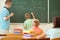 School boy with his teacher at the blackboard at math lesson in classroom at school