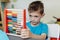 School boy learning maths with an abacus