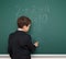 School boy solve math on school board