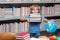 School boy with stack of books in library. Little student school child. Portrait of nerd student with school supplies.