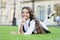 School break for rest. Happy smiling pupil. Girl cute kid laying green grass. Happy kid relaxing outdoors. Girl school