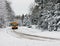 School Bus Driving Down A Snow Covered Rural Road - 1