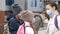 School children cross the road in medical masks. Children go to school