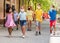 School children in protective medical masks walk along the street of a city