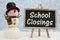 School Closings chalkboard sign with happy snowman with hat, ornaments, and snow